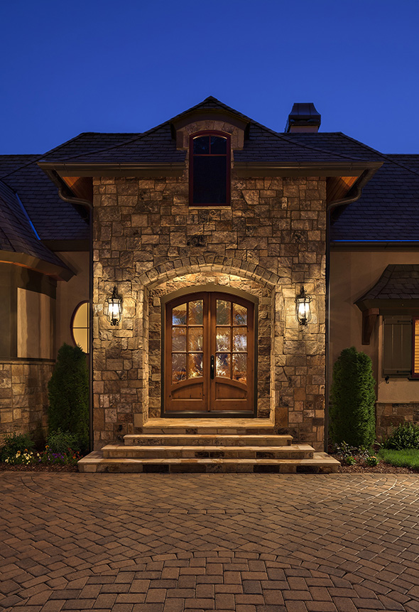 Set within stonework, a pair of knotty Alder doors with Flat Arch, finished in Sun Mountain’s Snake River glaze.